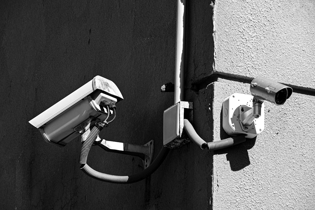 AI監視による自動取締りの全体像を示す都市の監視カメラと分析画面のイメージ